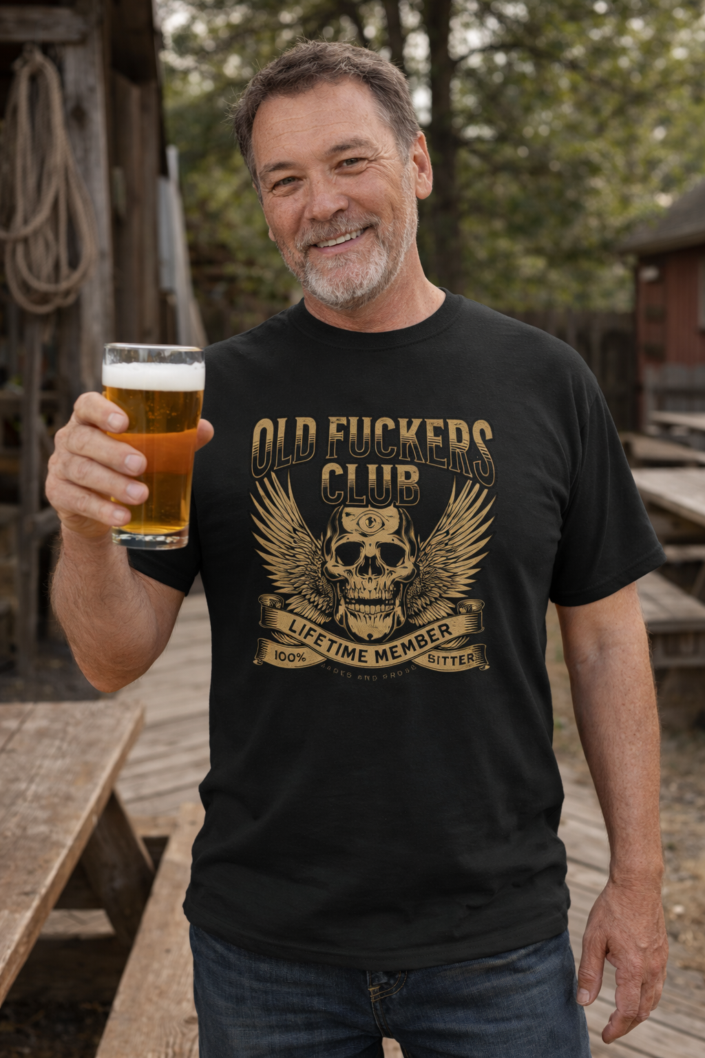 Lifestyle photo of mature bearded man wearing a sustainable unisex t shirt with vintage old fuckers club, fashion for men, gift for couples, anniversary gift for him, boomer t-shirt, soft breathable fabric, rugged bar and motorcycle style graphic tee