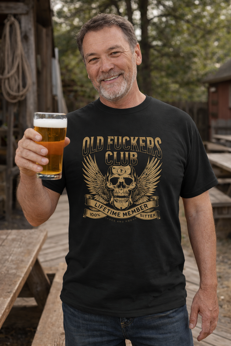 Lifestyle photo of mature bearded man wearing a sustainable unisex t shirt with vintage old fuckers club, fashion for men, gift for couples, anniversary gift for him, boomer t-shirt, soft breathable fabric, rugged bar and motorcycle style graphic tee